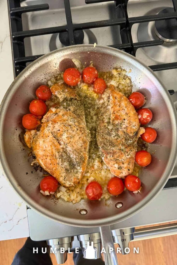 Tuscan Chicken with fresh tomatoes - tomatoes added to the pan.